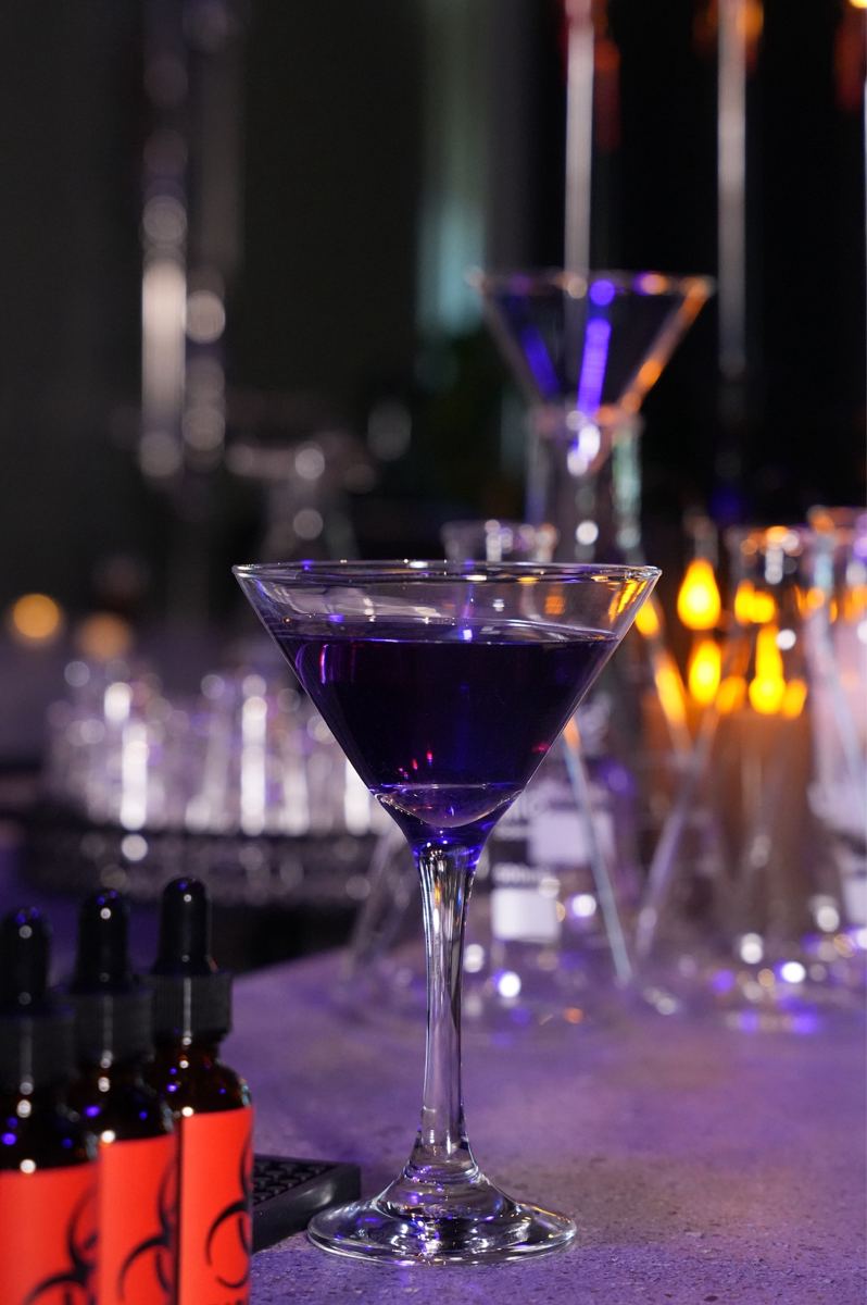 A violet cocktail in a martini glass