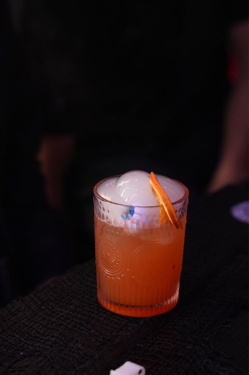 An orange cocktail with an eyeball ice sphere